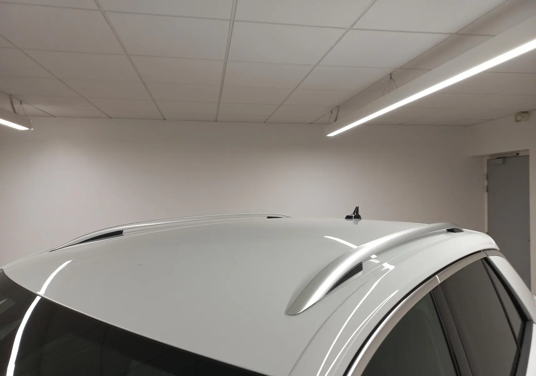 Vue rapprochée du toit blanc pur du Volkswagen T-Roc 2025 avec barres de toit et antenne requin.