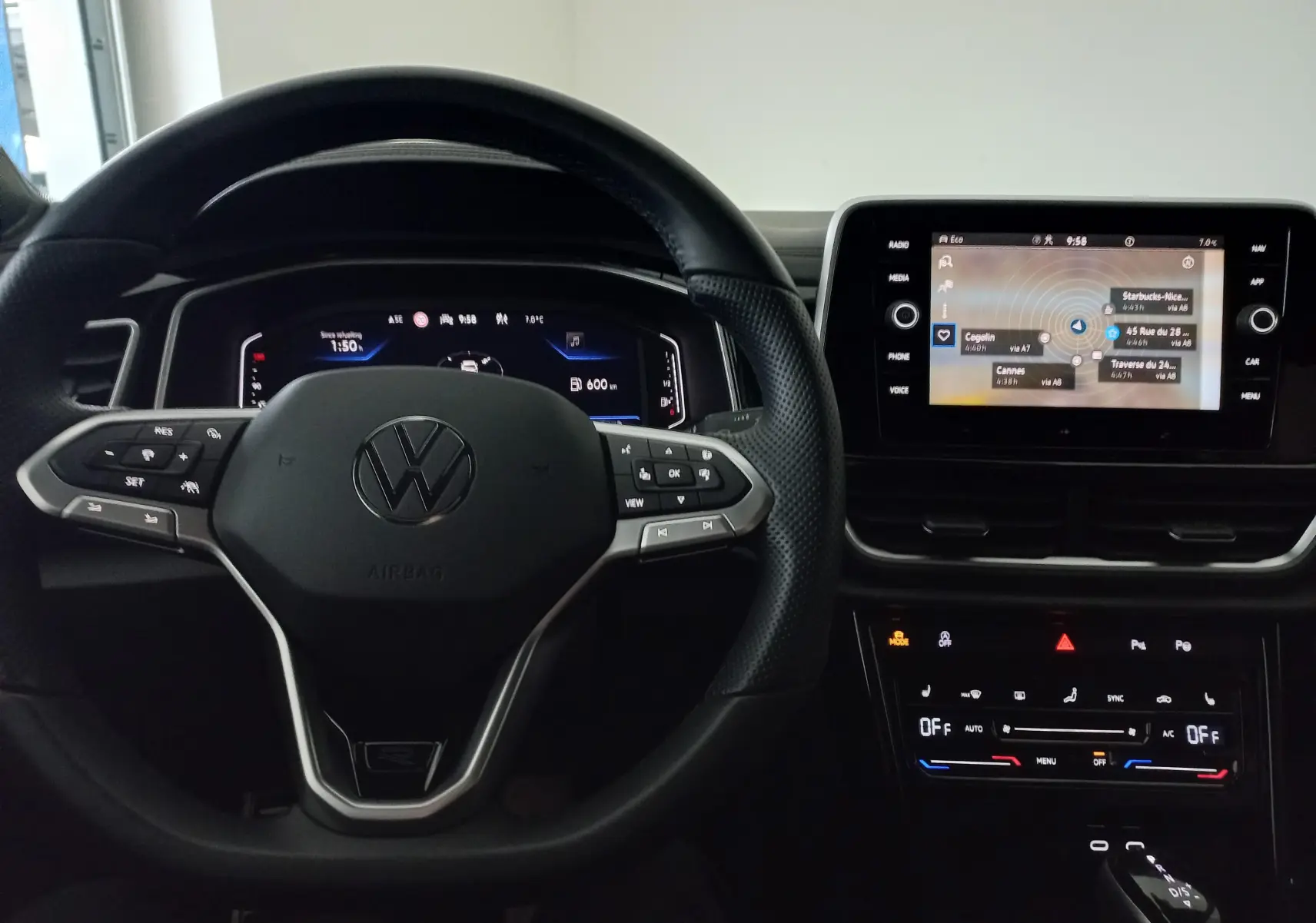 Vue intérieure centrée sur le volant multifonction noir et l’écran tactile du tableau de bord du Volkswagen T-Roc 2025.