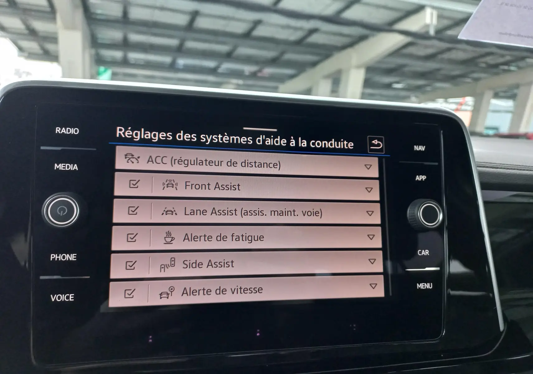 Écran tactile intérieur du Volkswagen T-Roc 2025 affichant les réglages des aides à la conduite.