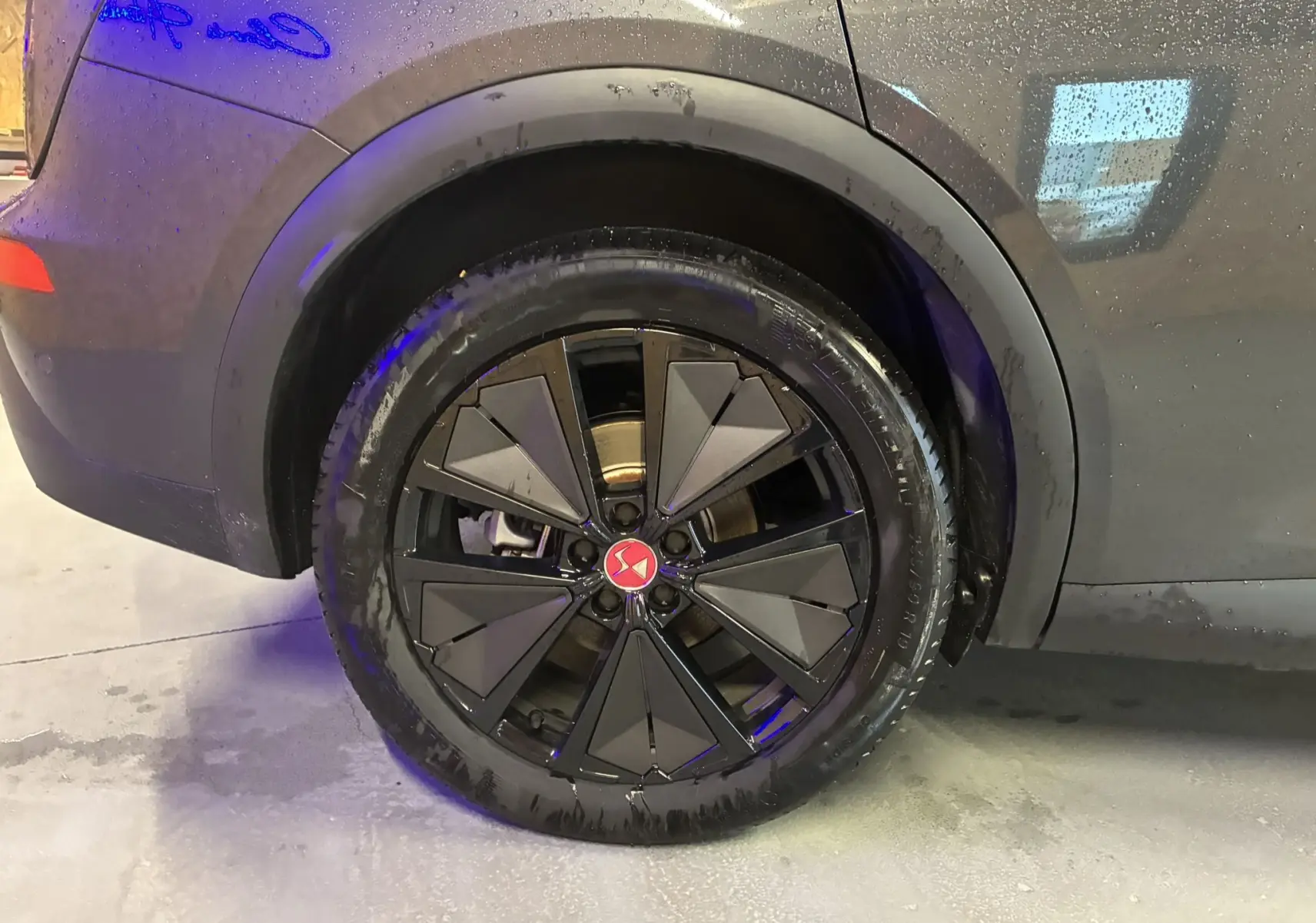 Gros plan sur la roue arrière droite du DS7 E-TENSE gris 2024 avec jante noire au design géométrique distinctif.