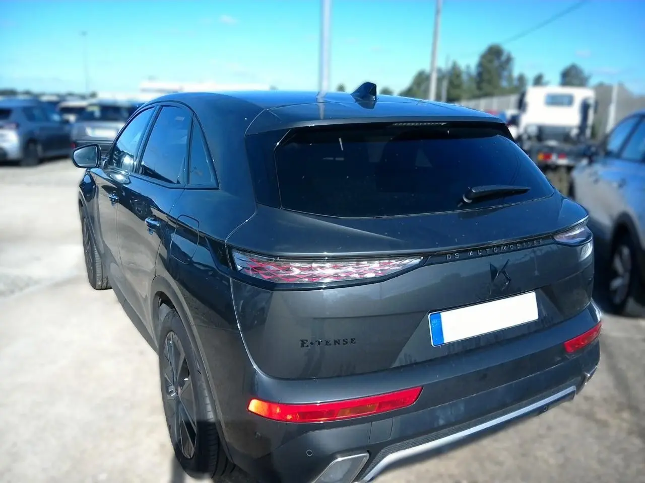 Vue 3/4 arrière droite d'un DS7 E-TENSE gris 2024 avec feux arrière LED et vitres teintées.