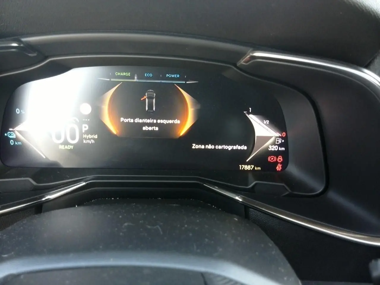 Vue rapprochée du tableau de bord numérique du DS7 E-TENSE 2024, affichant porte avant gauche ouverte et informations hybrides.