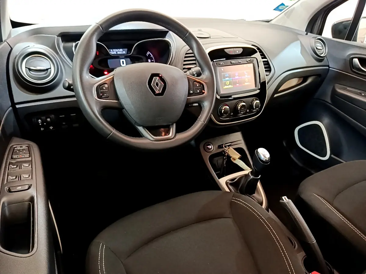 Vue intérieure avant du Renault Captur Business 2018, volant cuir multifonctions et écran tactile central visible.