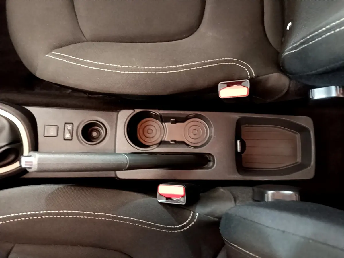 Vue plongeante sur la console centrale noire du Renault Captur gris foncé, avec frein à main et porte-gobelets.