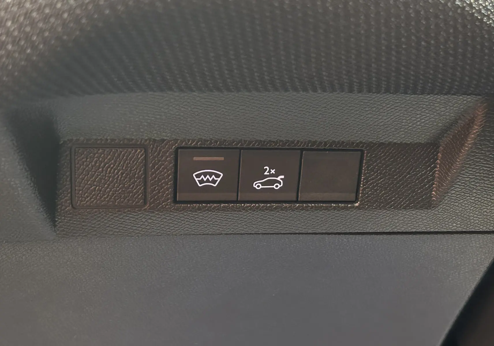 Boutons de commande du hayon électrique et du pare-brise chauffant sur le tableau de bord d'une Citroën C5 Aircross gris Platinium.