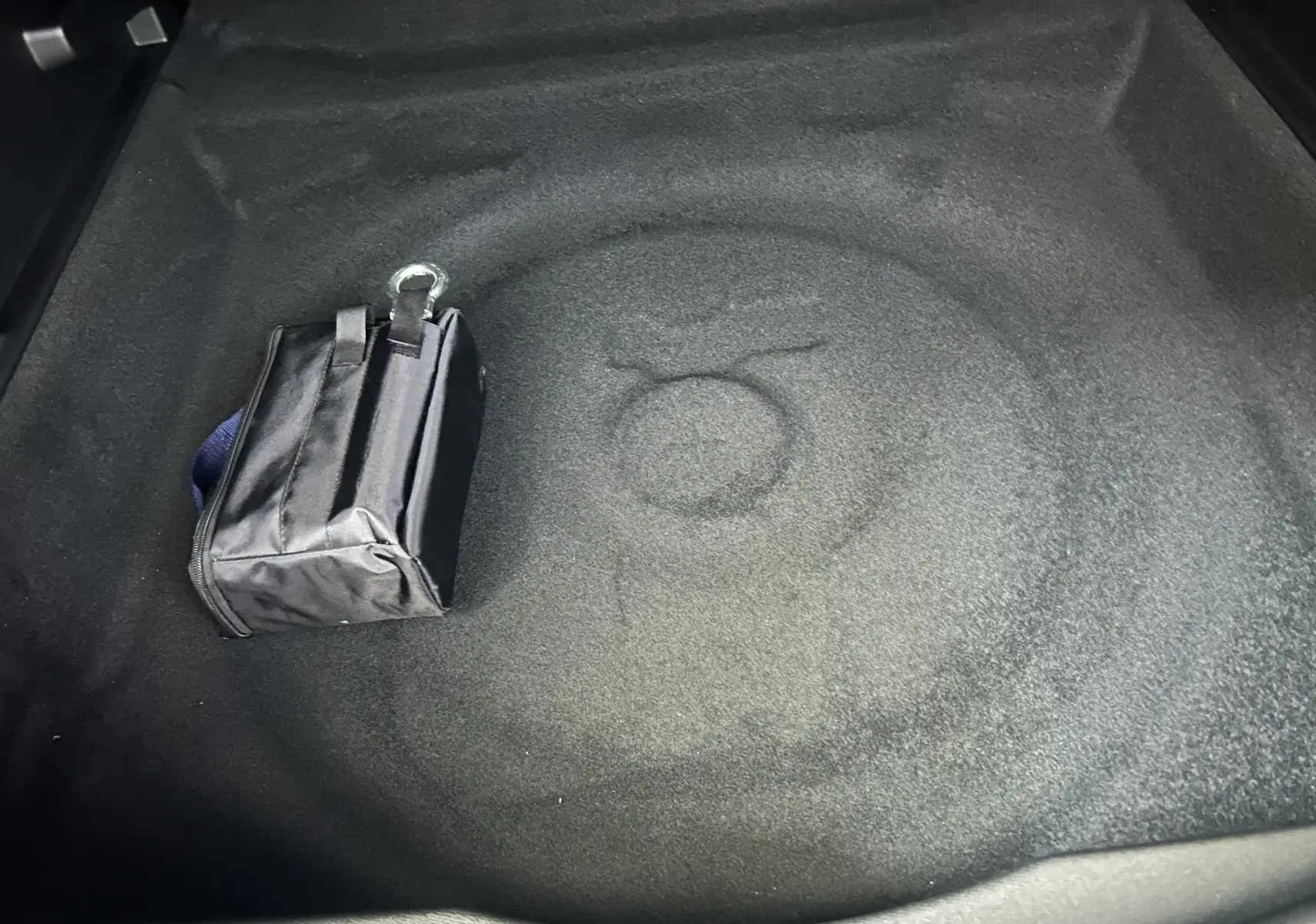 Coffre vide du Citroën C5 Aircross gris Platinium avec un petit sac noir posé, vue intérieure depuis l'arrière.