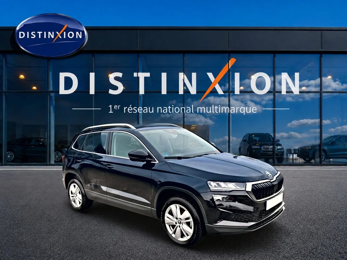 SUV Škoda Karoq noir vu en 3/4 avant droit devant une vitrine avec logo Distinxion.