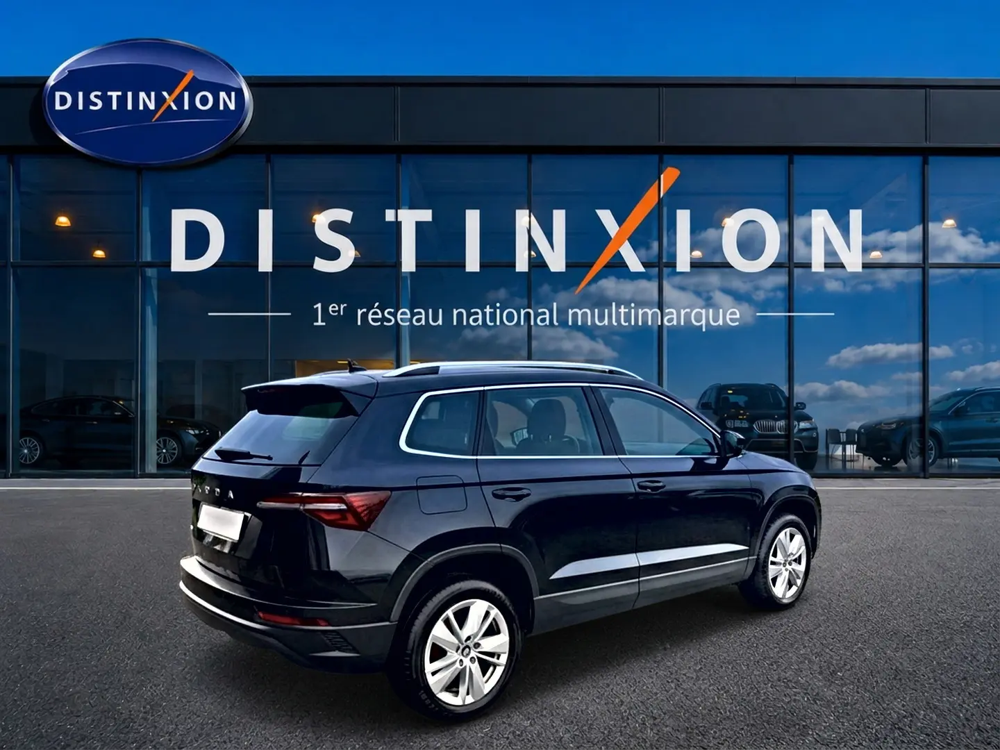 Vue 3/4 arrière droite d'un Skoda Karoq noir 2025 avec jantes alu devant une vitrine Distinxion.
