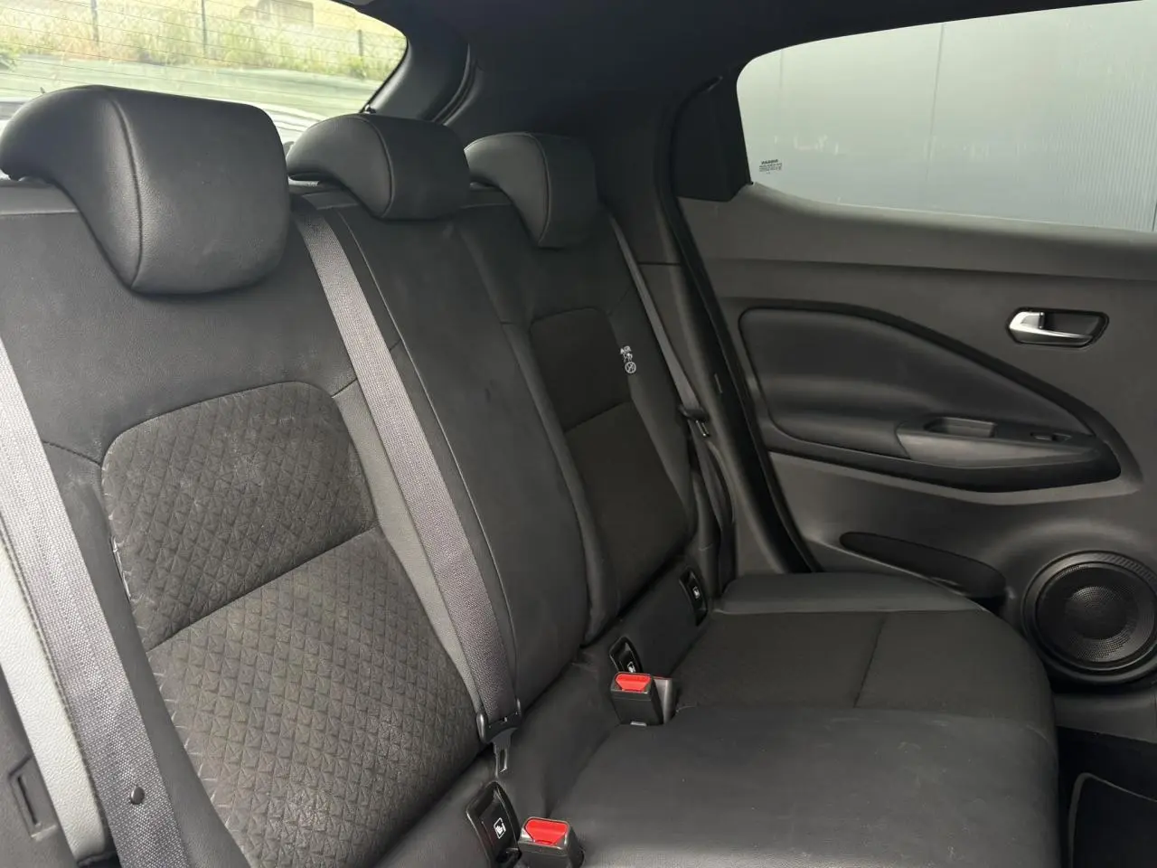 Vue latérale droite de la banquette arrière noire en tissu et TEP du Nissan Juke blanc perle 2024.