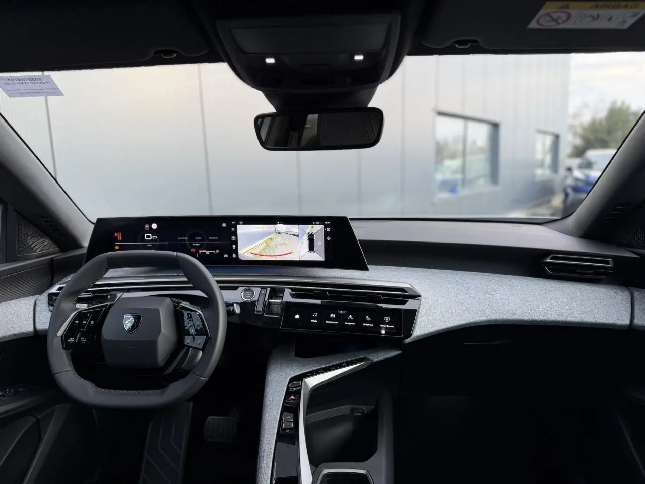 Vue intérieure avant du Peugeot 3008 Hybrid blanc Okénite, avec tableau de bord i-Cockpit panoramique et écran incurvé 21 pouces.