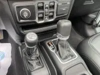 Gros plan sur la console centrale du Jeep Wrangler Unlimited 2023, montrant les leviers de vitesses et les commandes.