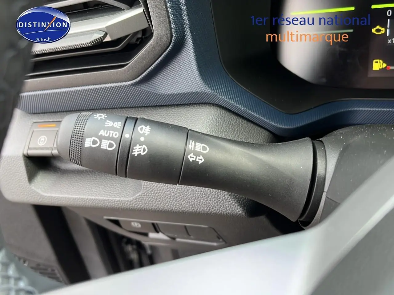 Gros plan sur la commande des feux et clignotants du tableau de bord du Dacia Duster gris schiste 2025.