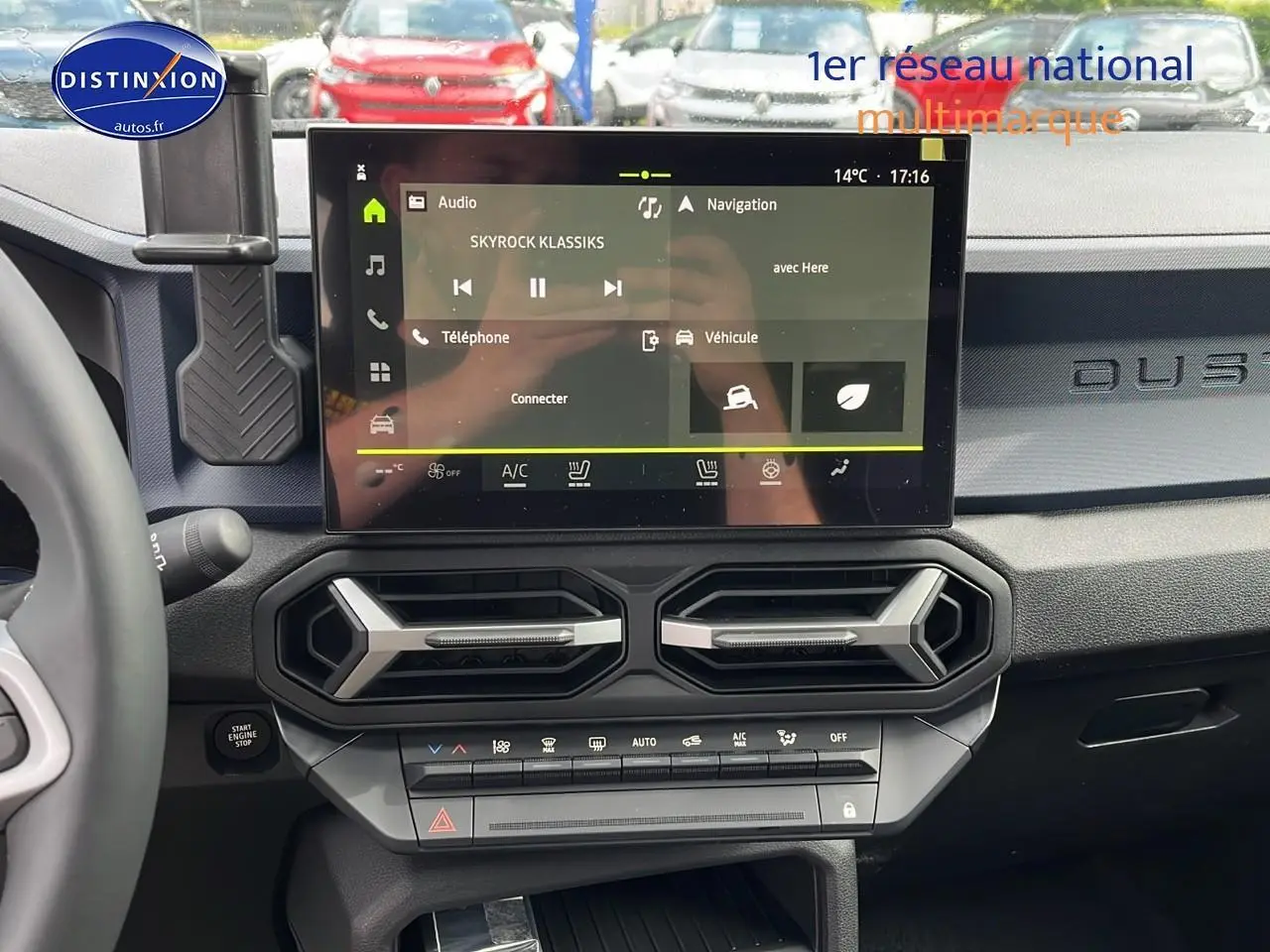 Tableau de bord du Dacia Duster gris schiste 2025 avec écran tactile central et aérateurs hexagonaux.