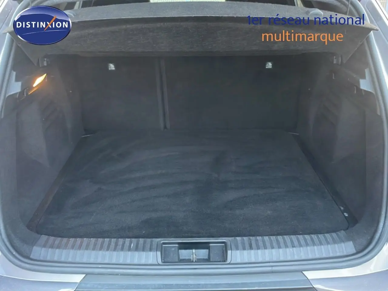 Coffre ouvert vu de l'arrière d'une Renault Symbioz gris cassiopée métal, montrant un espace de chargement vide et propre.