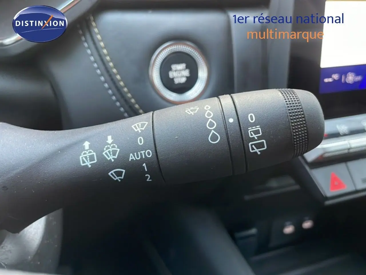 Gros plan sur la commande d’essuie-glace du Renault Symbioz gris cassiopée métal, avec bouton Start Engine Stop en arrière-plan.