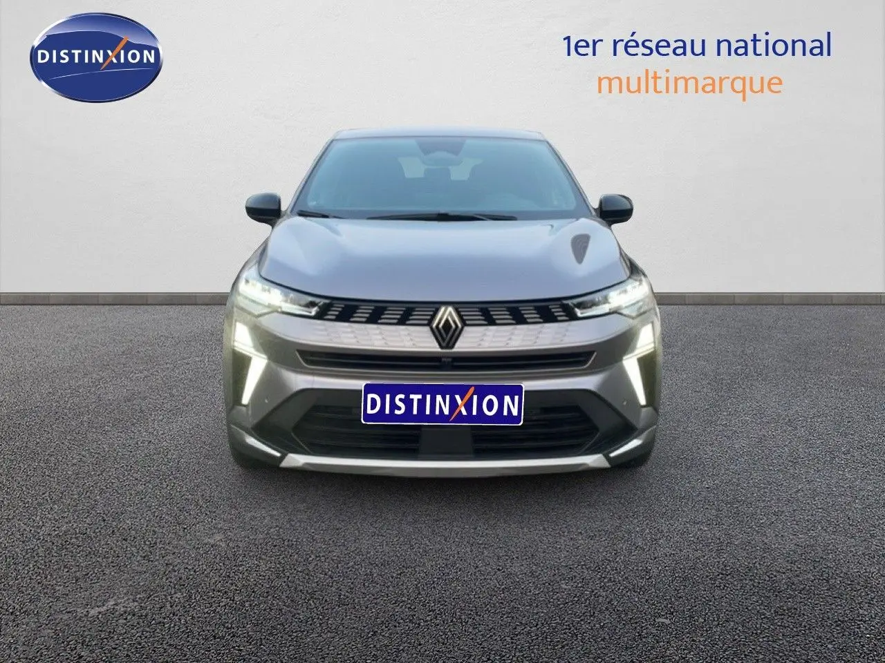 Vue avant d'une Renault Symbioz gris cassiopée métal avec feux LED allumés sur fond neutre.