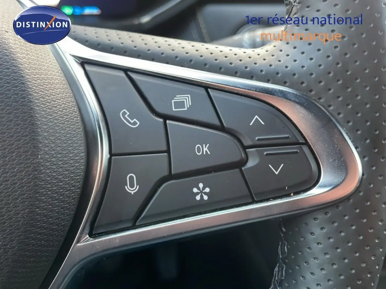 Détail des commandes multifonctions sur le volant perforé noir du Renault Symbioz gris cassiopée métal.