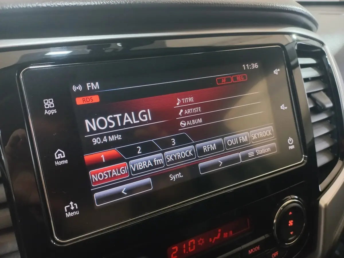 Écran tactile central du tableau de bord du Mitsubishi L200 gris foncé, affichant la radio FM sur Nostalgie.