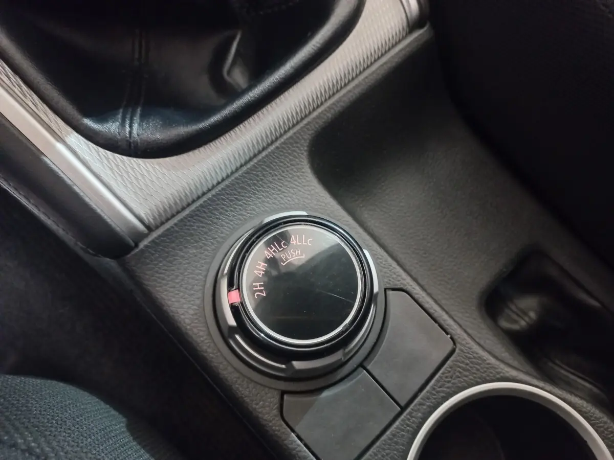 Gros plan sur le sélecteur de mode 4x4 dans l’habitacle noir du Mitsubishi L200 gris foncé, version 2020.