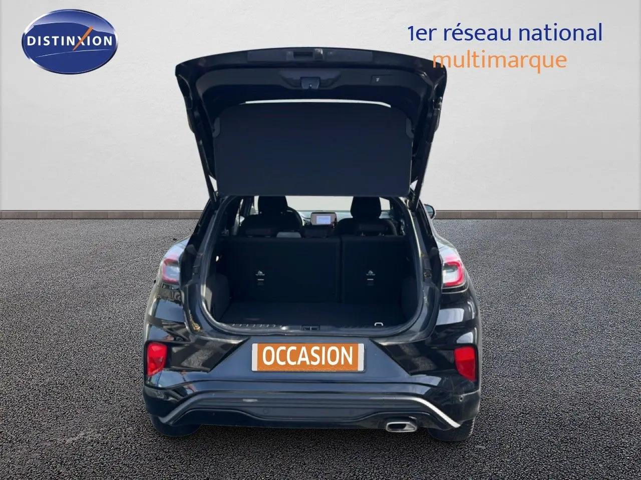 Vue arrière d'un Ford Puma noir Agate Metal 2023 avec hayon ouvert montrant le coffre vide.