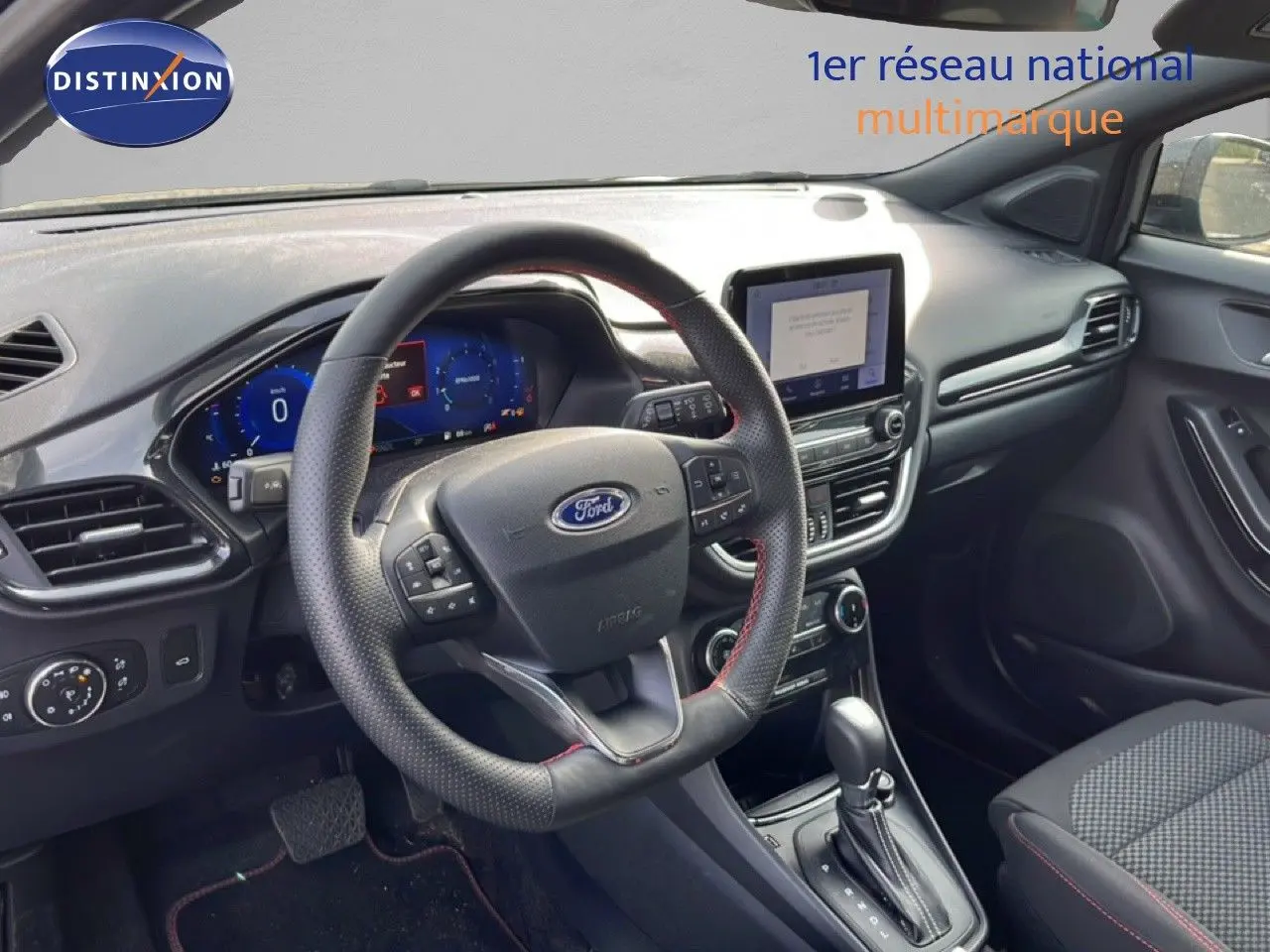 Vue intérieure du tableau de bord et volant de la Ford Puma noir agate métal avec écran tactile et boîte automatique.