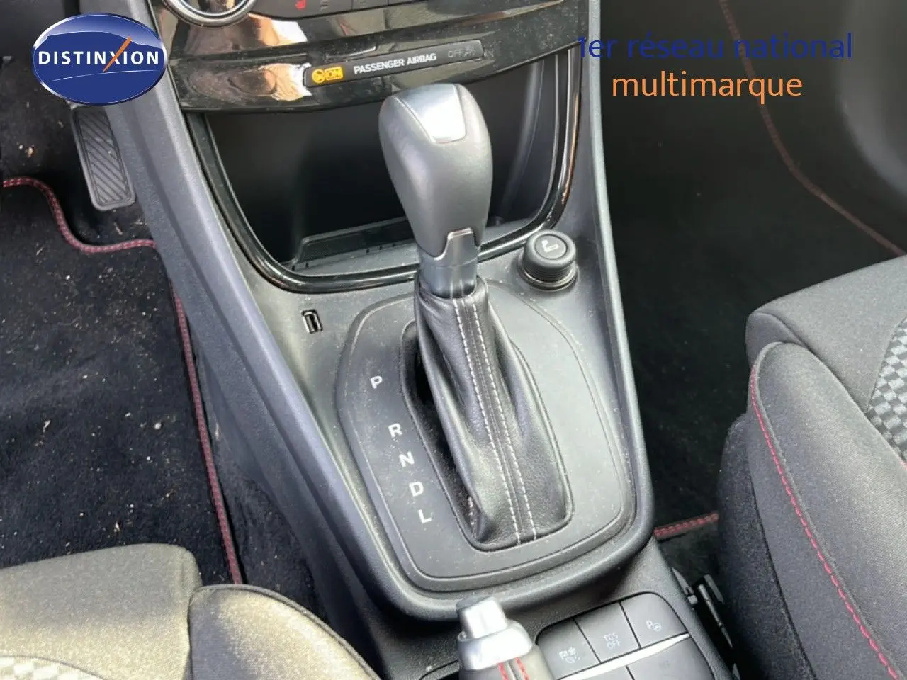Vue rapprochée de la console centrale du Ford Puma noir agate, mettant en valeur le levier de vitesses automatique et les commandes adjacentes.