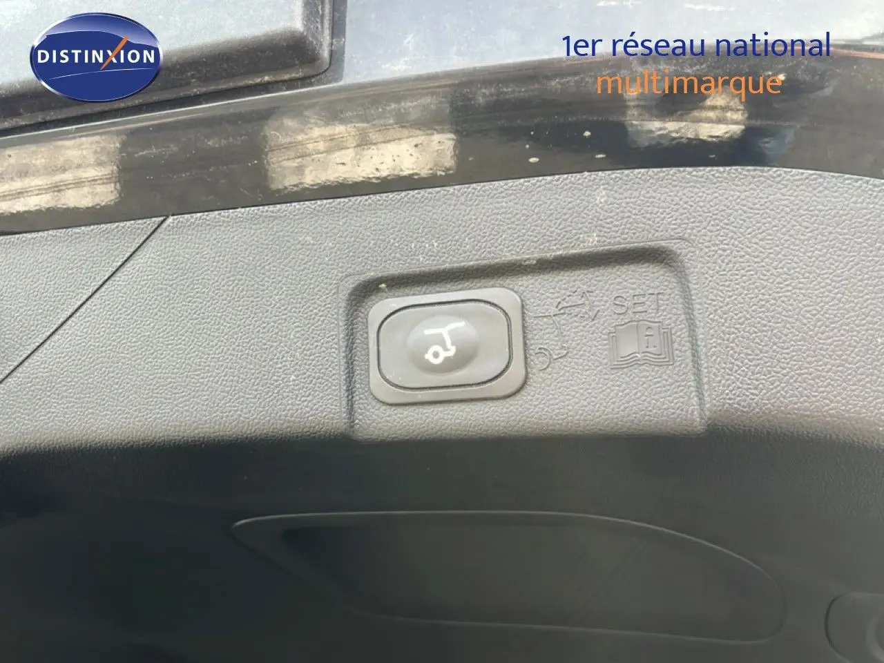 Bouton d'ouverture électrique du hayon sur le bord intérieur du coffre d'un Ford Puma noir Agate Metal 2023.