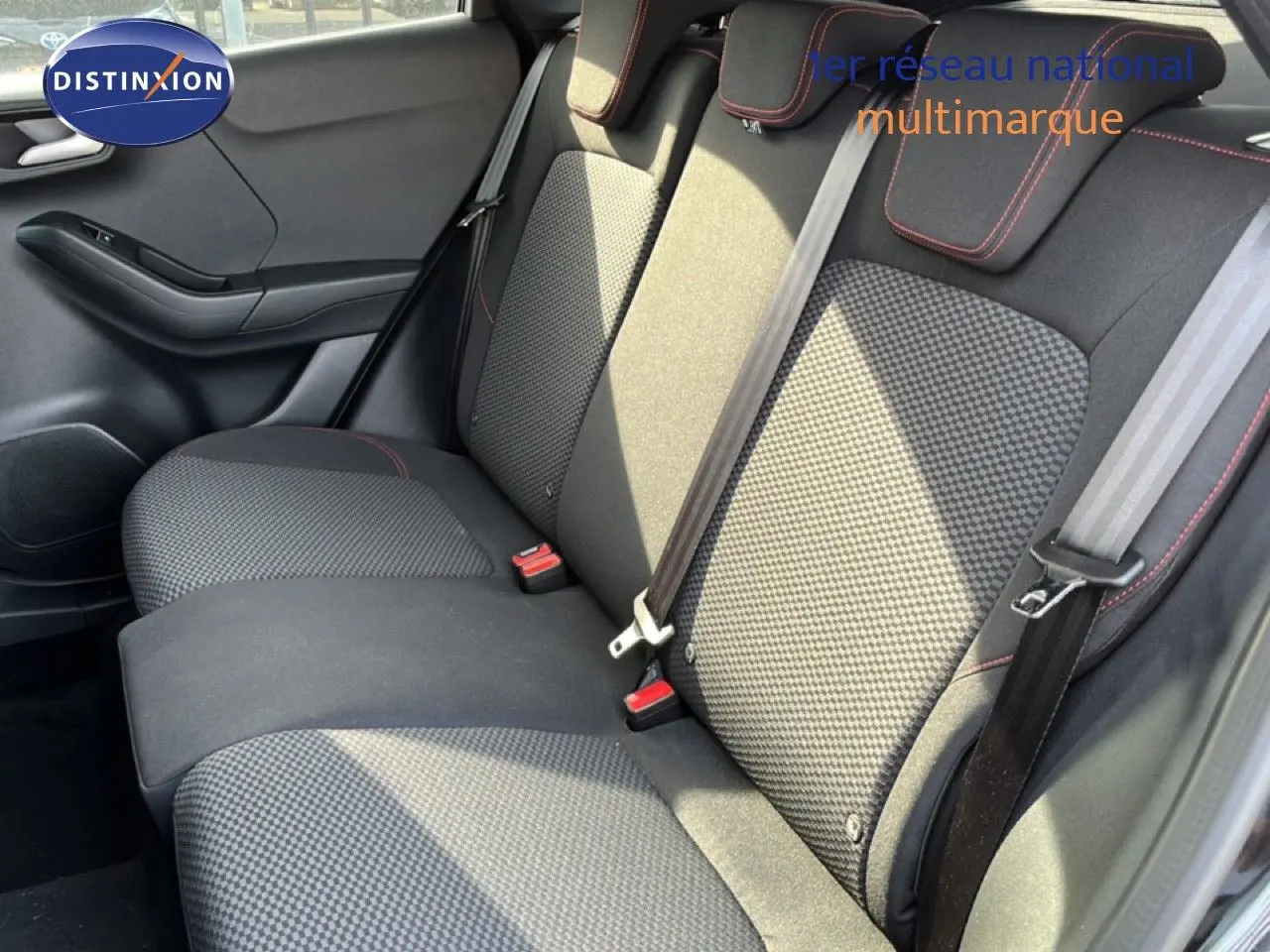 Vue intérieure côté droit montrant la banquette arrière en tissu noir avec surpiqûres rouges du Ford Puma 2023.