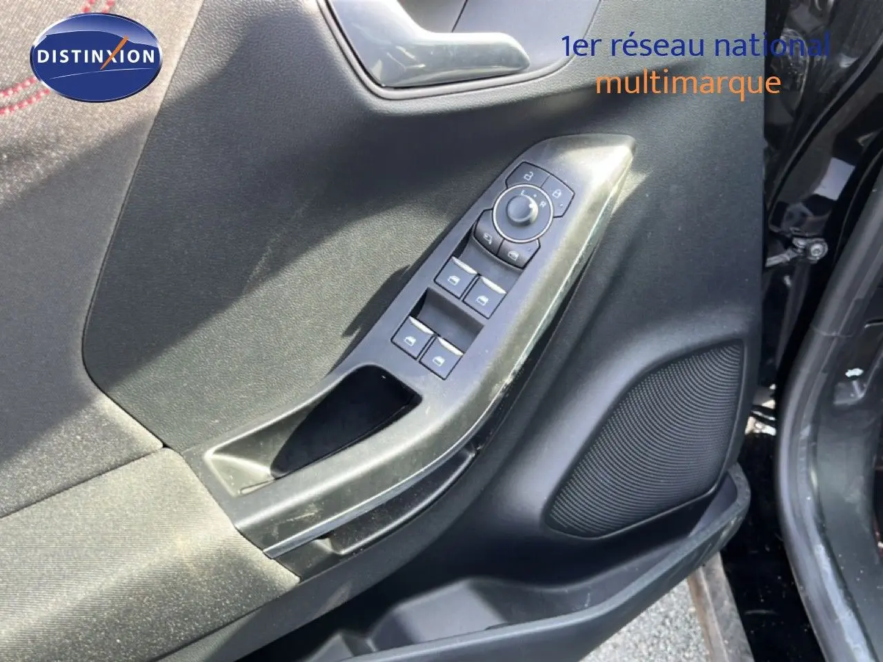 Gros plan sur la commande des vitres et rétroviseurs côté conducteur d’un Ford Puma noir Agate Metal 2023.