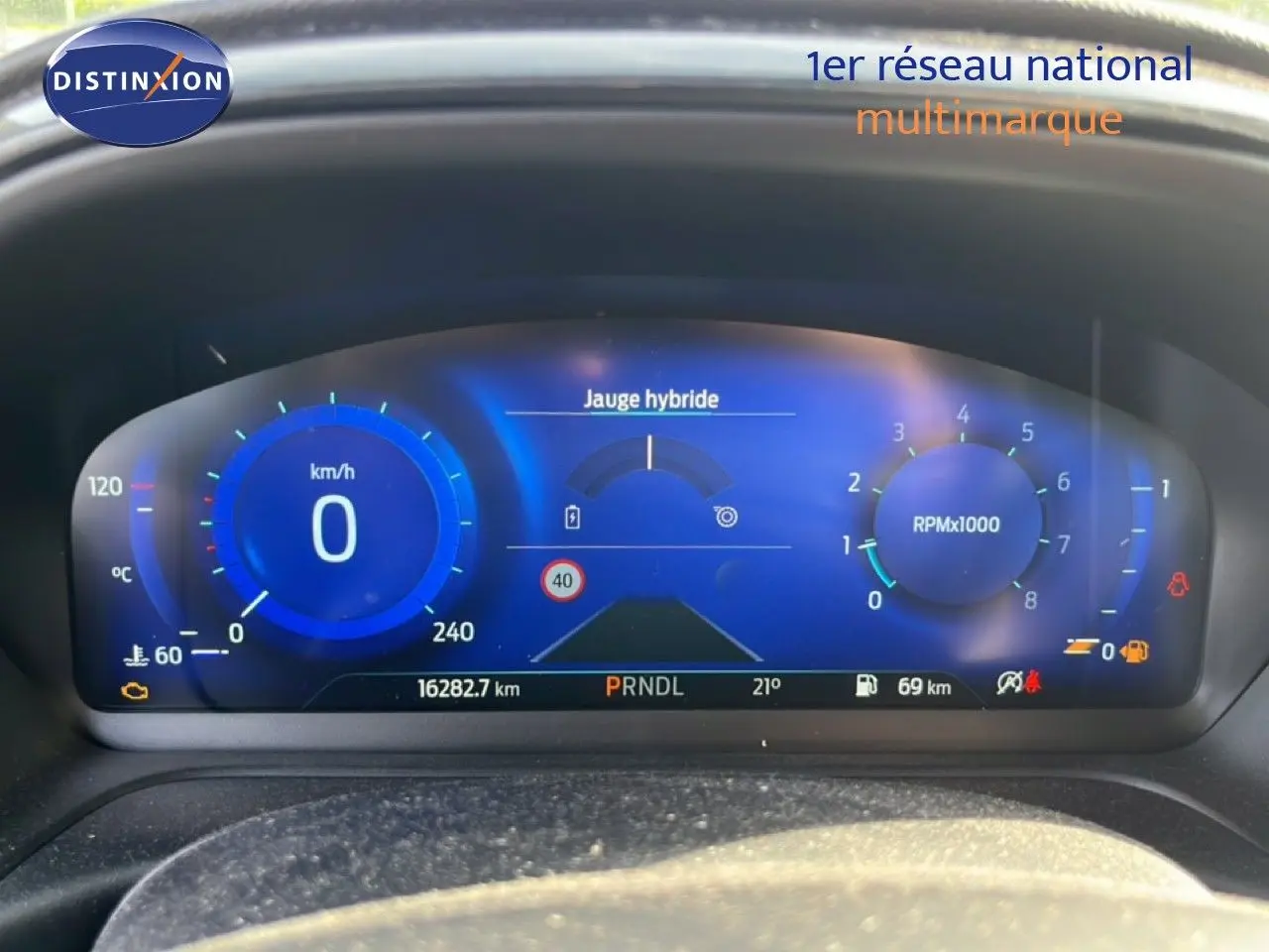 Tableau de bord numérique bleu du Ford Puma 2023, affichant vitesse, jauge hybride et compte-tours.