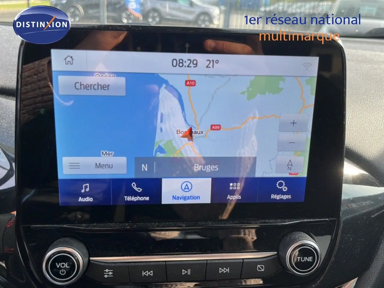 Vue rapprochée de l’écran tactile du Ford Puma noir agate 2023, affichant la navigation GPS vers Bruges.