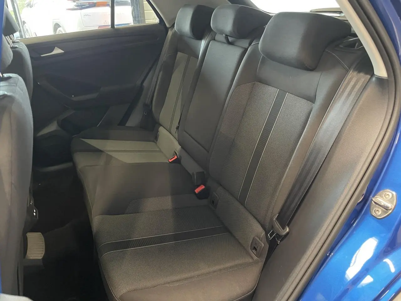 Vue intérieure côté droit sur la banquette arrière en tissu noir du Volkswagen T-Roc bleu 2022.