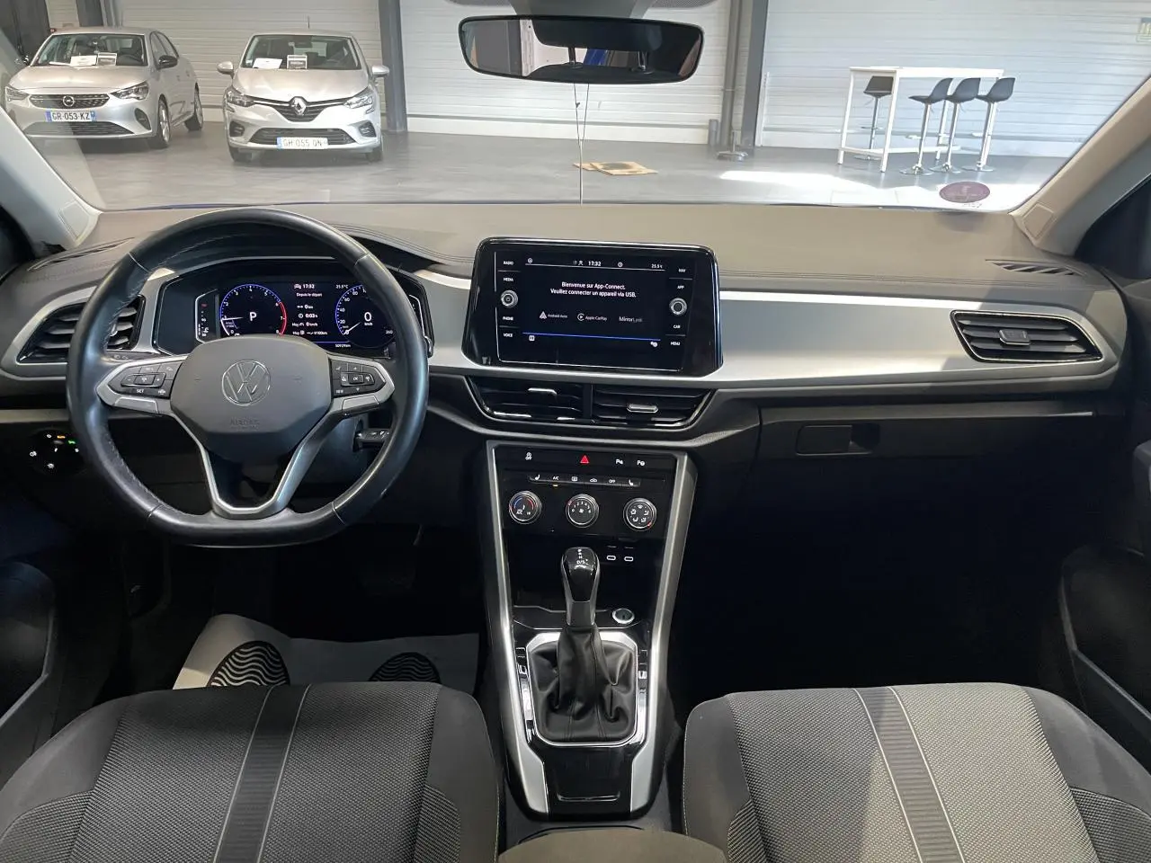 Intérieur avant du Volkswagen T-Roc bleu 2022, vue centrée sur le tableau de bord et le volant multifonction.
