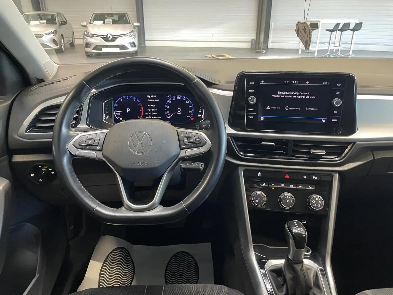 Vue intérieure du tableau de bord et volant cuir noir du Volkswagen T-Roc 2022 avec écran tactile central allumé.