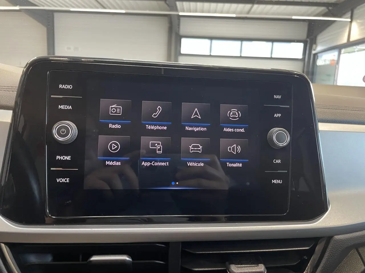 Écran tactile central du Volkswagen T-Roc 2022 affichant les options radio, téléphone, navigation et aides à la conduite.