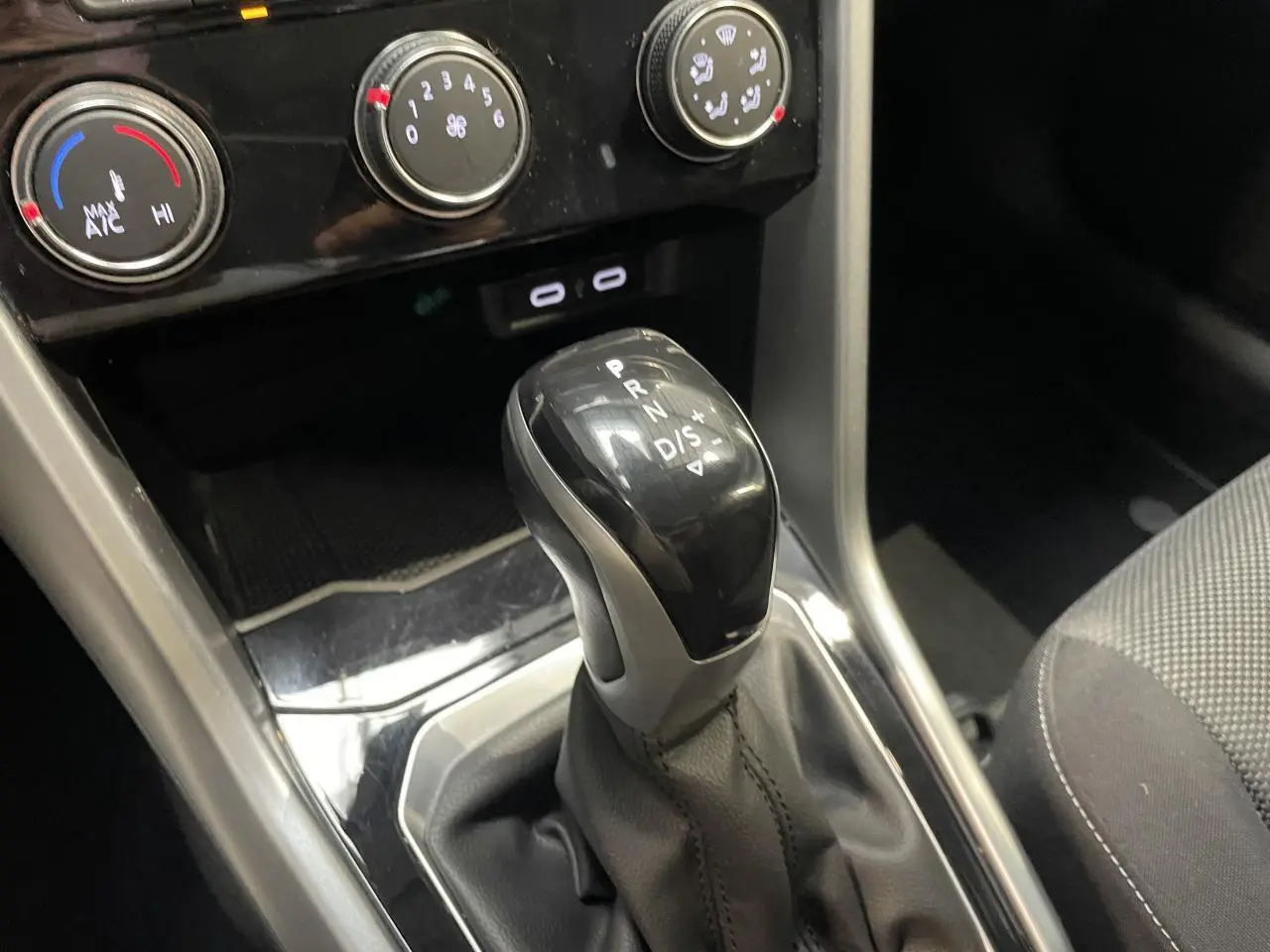 Le levier de vitesse automatique noir du Volkswagen T-Roc 1.5 TSI Evo, vu en gros plan intérieur.
