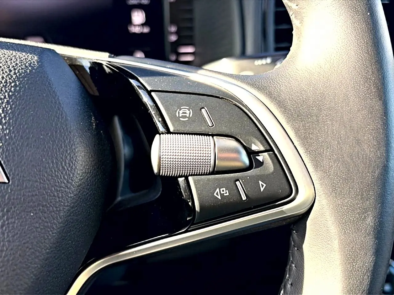 Gros plan sur les commandes noires et argent du volant cuir du Skoda Karoq gris, version 1.5 TSI 2025.