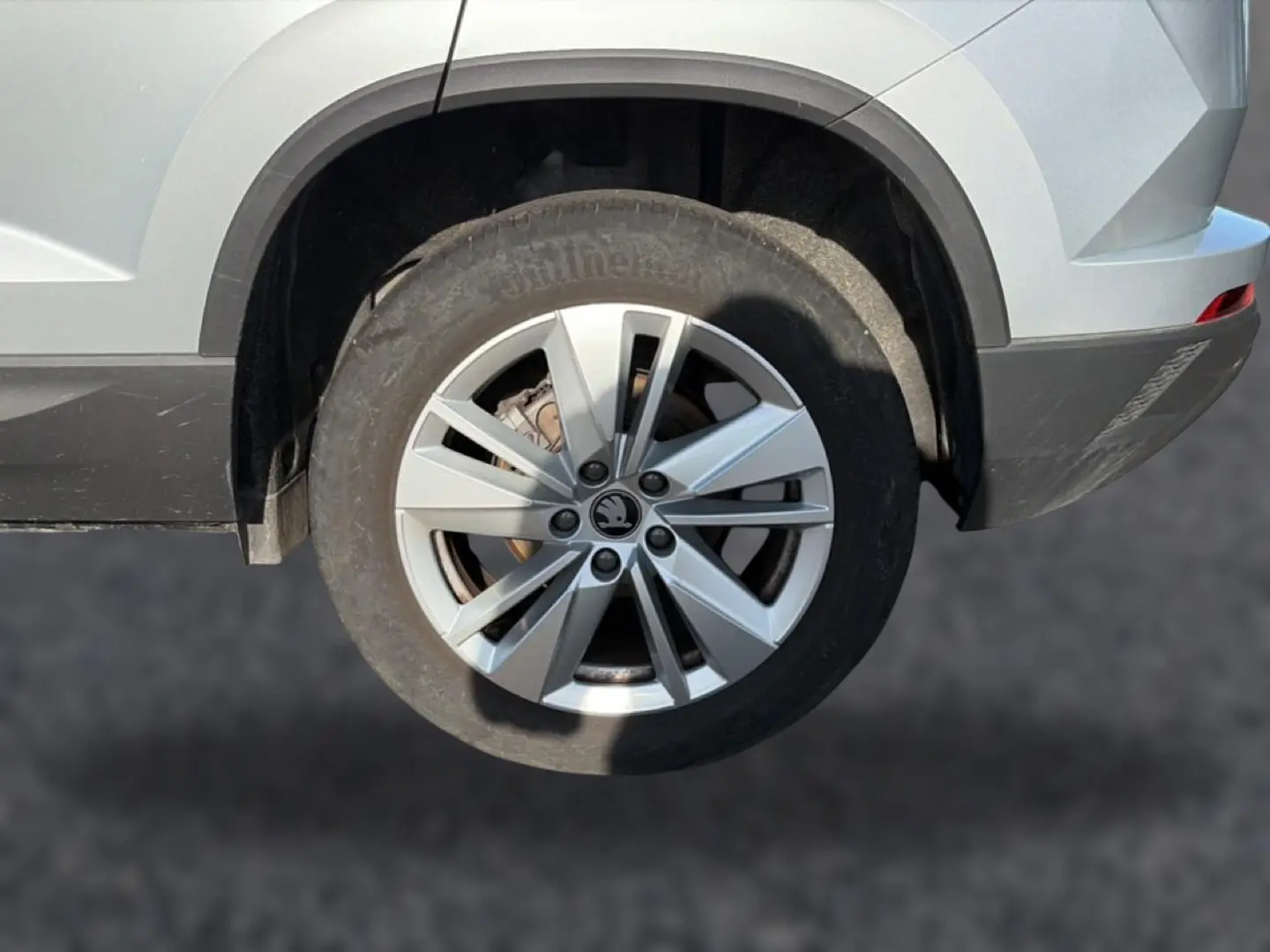 Gros plan sur la roue arrière droite gris clair d’un Skoda Karoq 2025 avec jante alu à plusieurs branches.