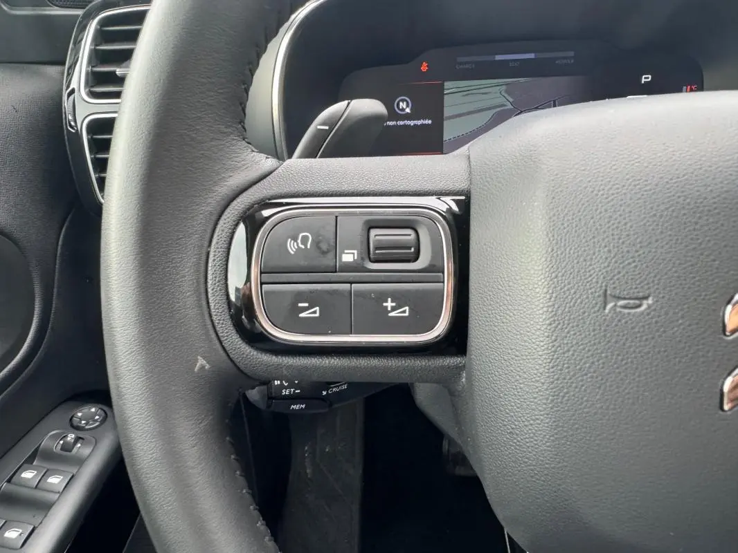 Gros plan sur le volant du Citroën C5 Aircross bleu foncé, avec commandes audio et régulateur au volant.