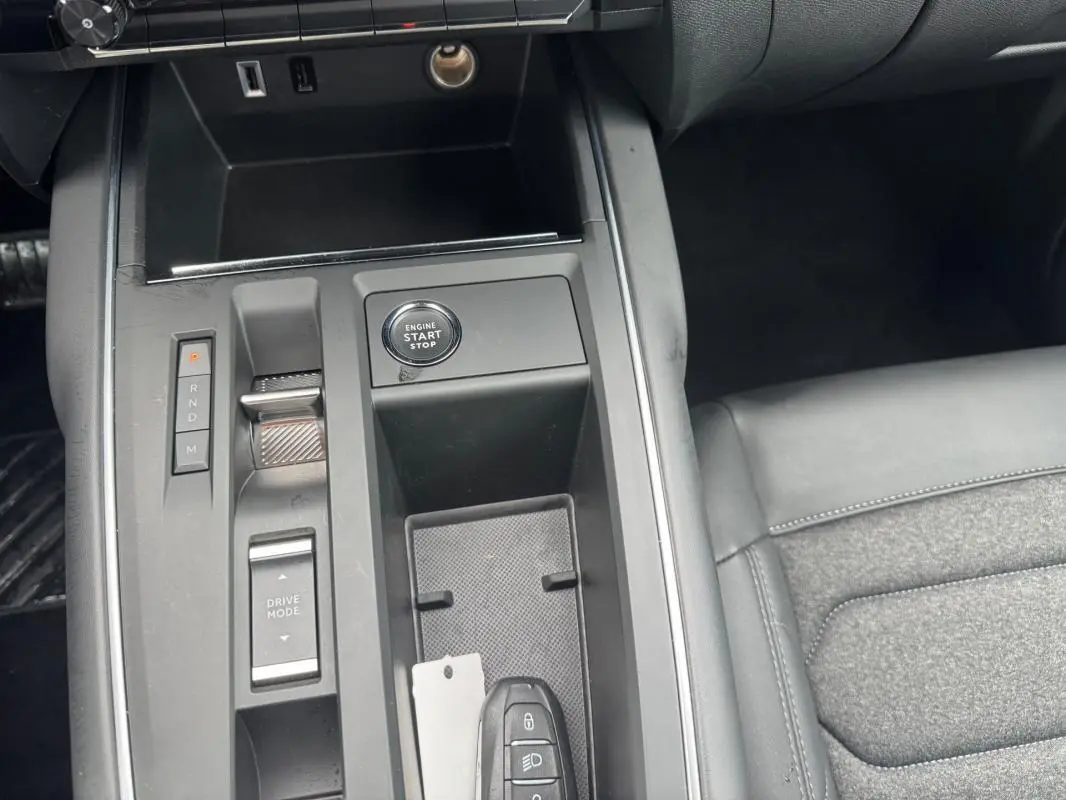 Gros plan sur la console centrale noire du Citroën C5 Aircross 2024, avec bouton start/stop et sélecteur de boîte automatique.
