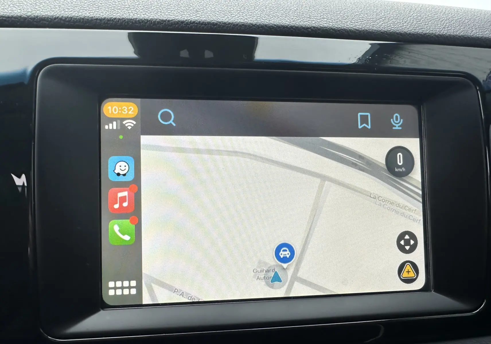 Écran tactile du système de navigation du Kia Niro hybride rechargeable, affichant une carte et des icônes d'applications.