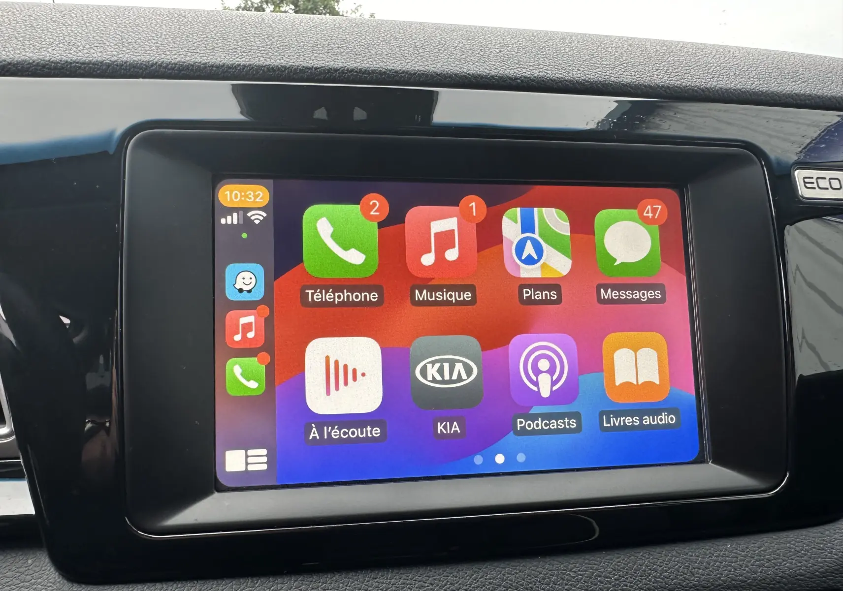 Écran tactile central du Kia Niro 2020 affichant les applications téléphonique, musique, plans et messages dans un intérieur noir.