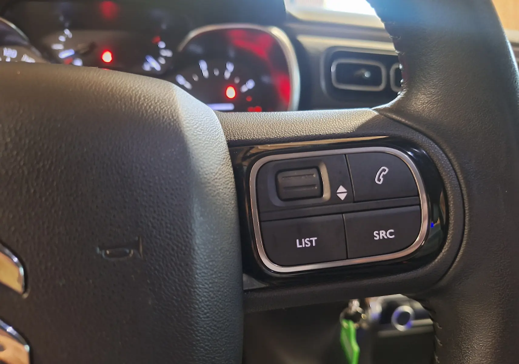 Gros plan sur le volant cuir de la Citroën C3 1.5 BlueHDi 100 Shine, avec commandes audio intégrées.