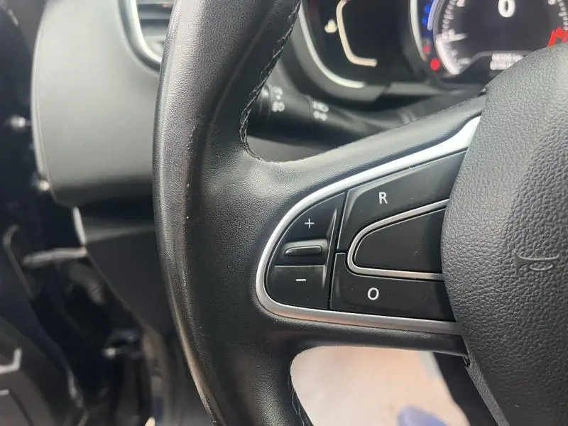 Gros plan sur les commandes du volant en cuir noir du Renault Grand Scenic Bleu Cosmos 2022, avec boutons de régulation.