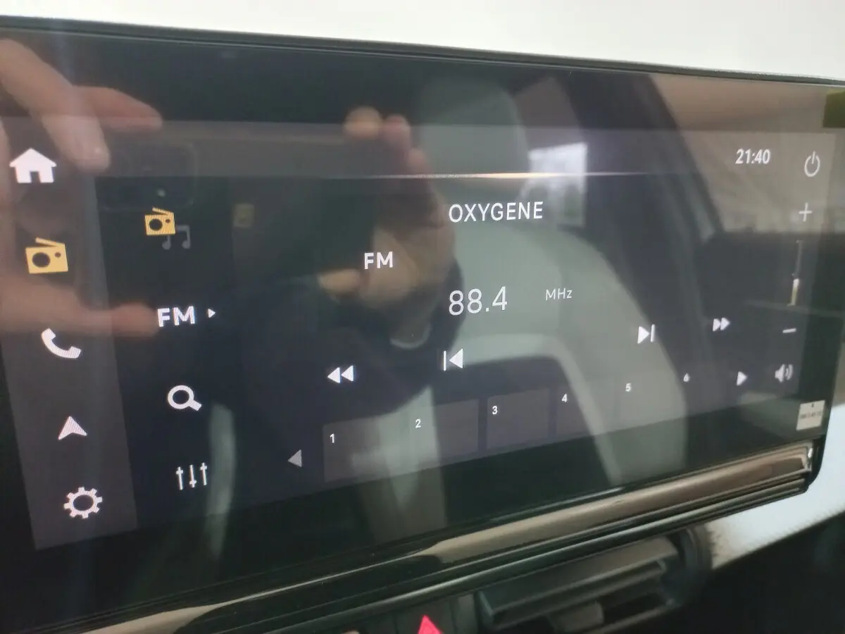 Écran tactile central de la Citroën C3 hybride gris foncé affichant la radio FM à 88,4 MHz en intérieur.