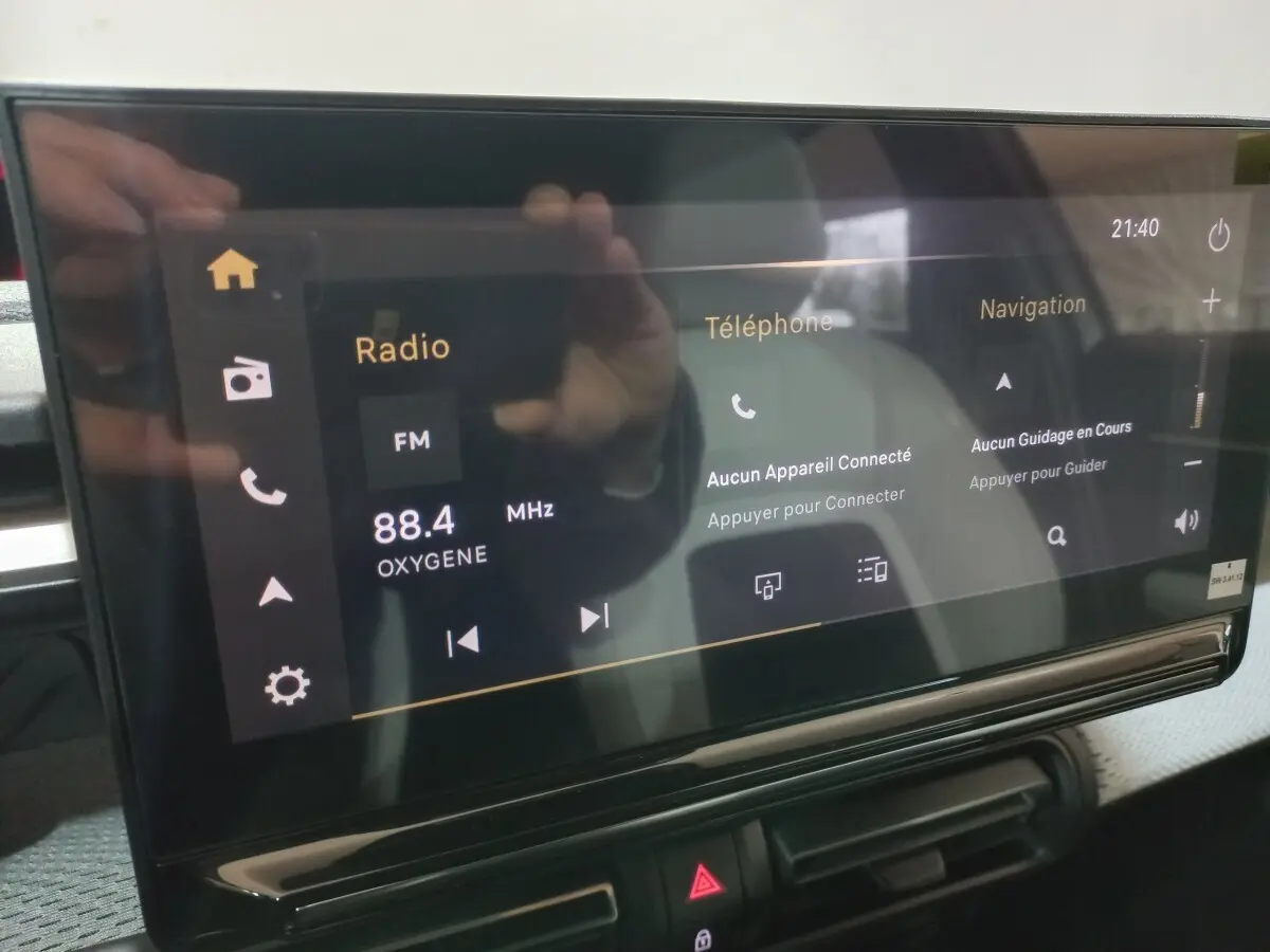 Écran tactile central de la Citroën C3 hybride gris foncé, affichant radio, téléphone et navigation.