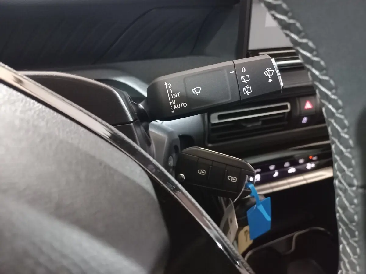 Gros plan sur la commande d’essuie-glace et la clé noire dans l’habitacle d’une Citroën C3 hybride 2025.