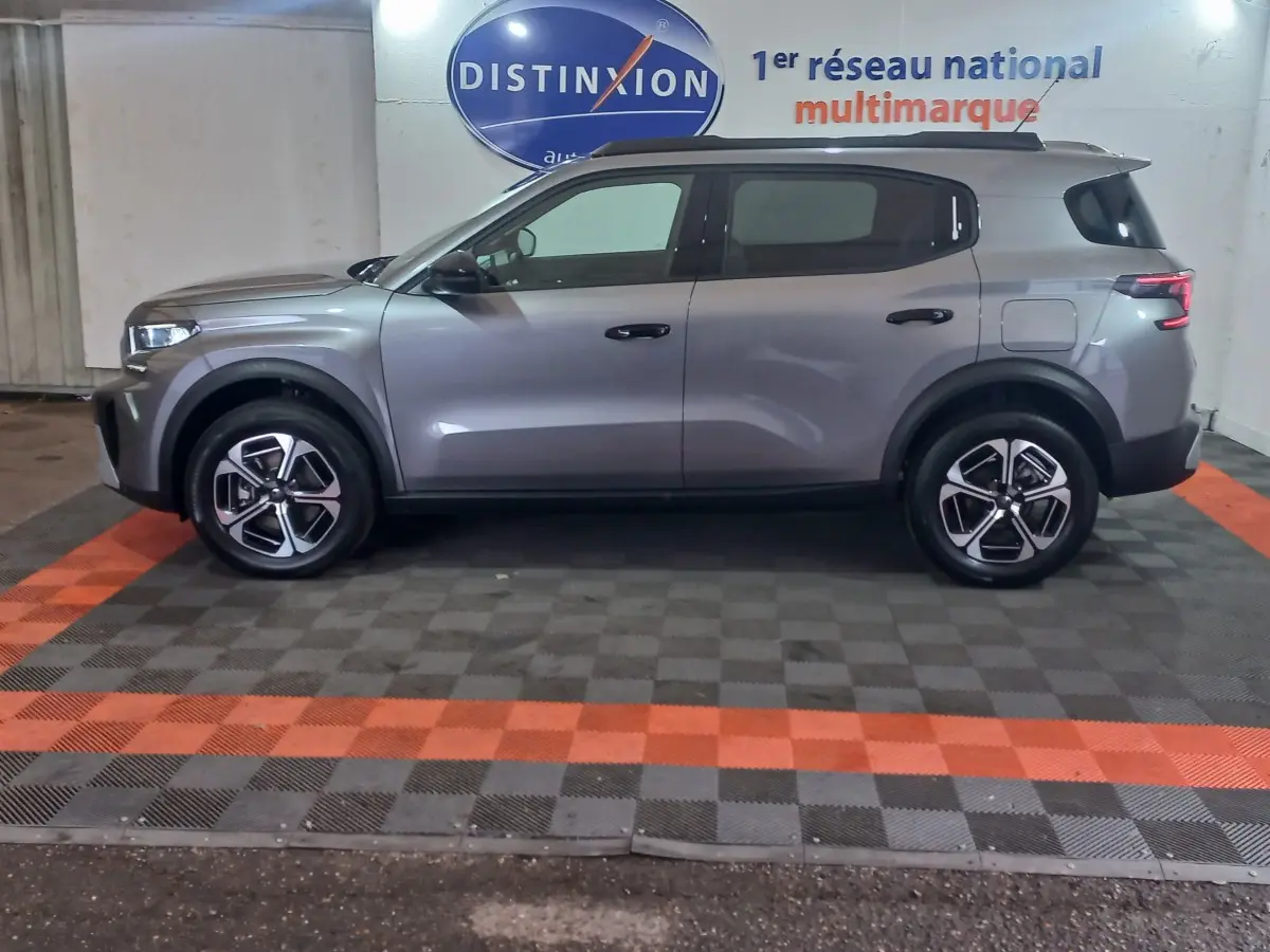 Vue latérale droite d'une Citroën C3 hybride gris foncé, avec jantes modernes et lignes épurées.