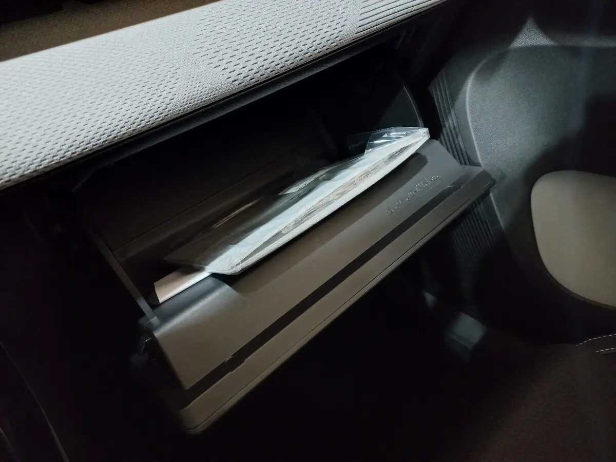 Gant de boîte à gants ouvert côté passager dans l'habitacle sombre d'une Citroën C3 hybride gris foncé 2025.