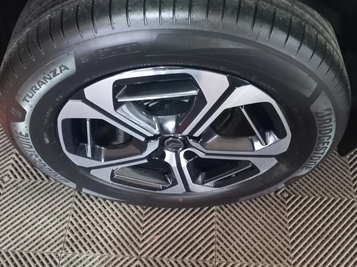 Gros plan sur la roue avant d’une Citroën C3 hybride 2025, jante alliage bicolore et pneu Bridgestone Turanza.